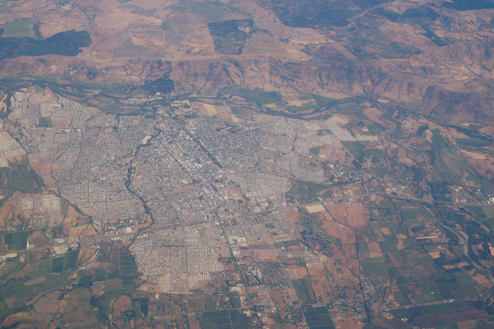 Vista aérea de Talca: la mancha urbana, el río y las parcelas agrícolas que la rodean.